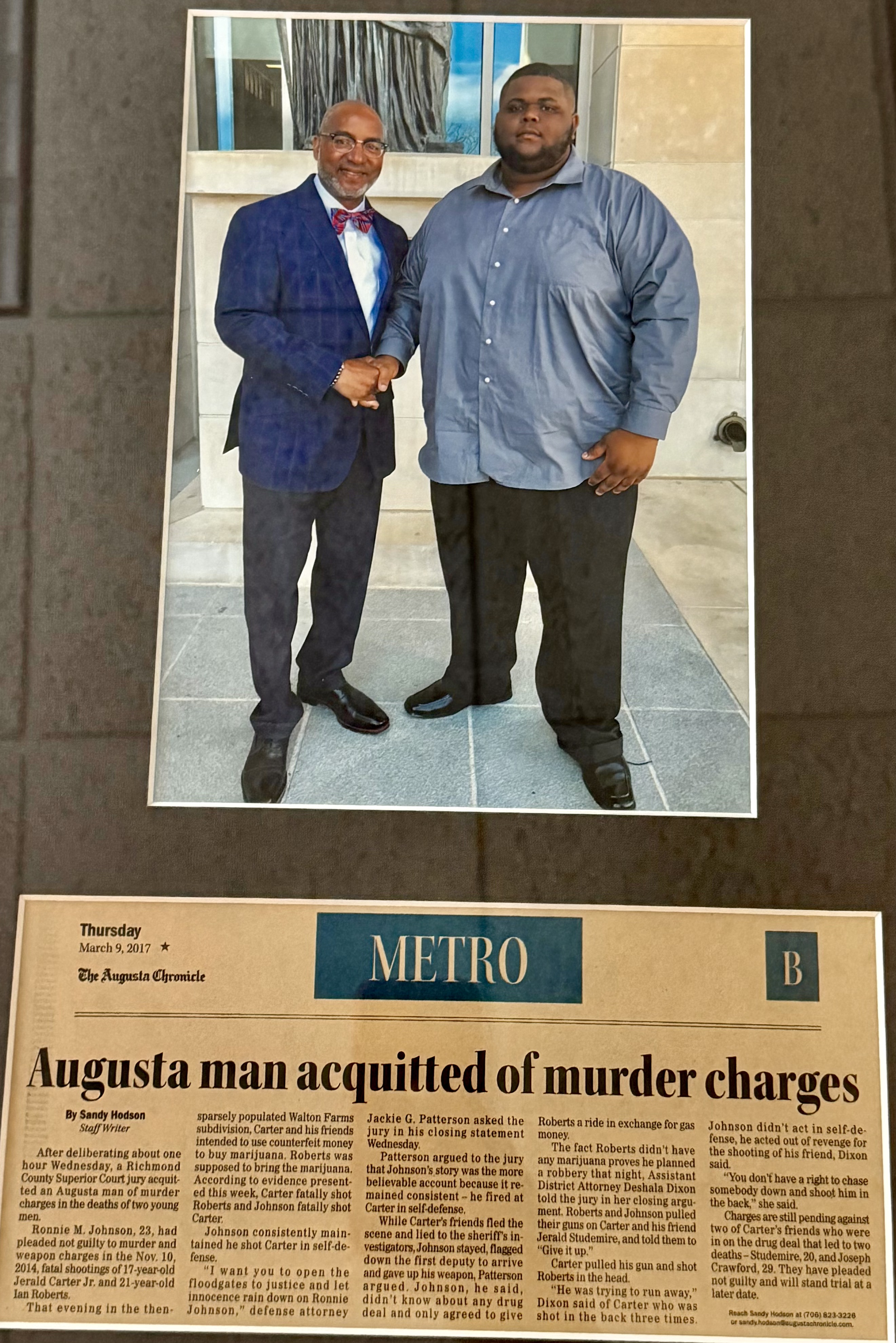 Jackie Patterson with a client outside the courthouse above the Augusta Chronicle article on the murder-charge acquittal he won
